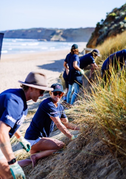 Lakey Peterson (WSL) and Scott Hines (Great Ocean Road Coast and Parks Authority) weeding out the introduced weed Marram Grass.